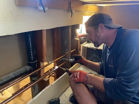 Technician in cap and gloves working on water treatment installation